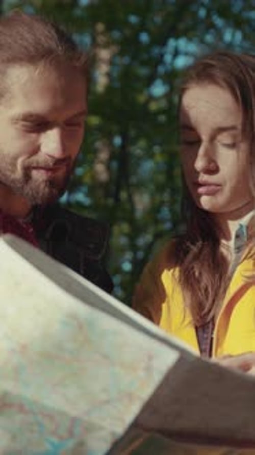 Young Couple Looks at Map While Hiking