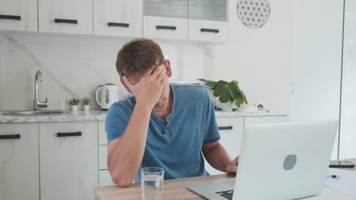 Frustrated Man Working on Laptop at Home