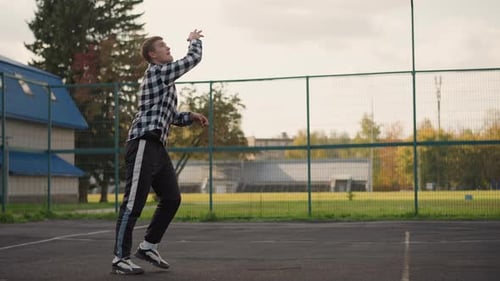 Man Throwing Volleyball to Slam in Outdoor Court with Green Field Background