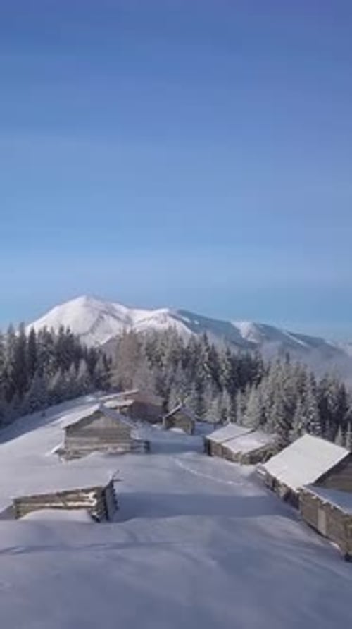 Aerial View of Snowcovered Cabins in a Mountainous Winter Landscape