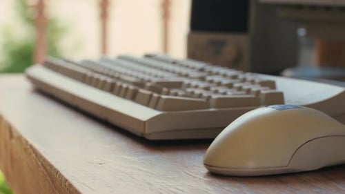 Hombre trabajando y jugando en una computadora retro, ingeniero de TI con una computadora antigua en casa usando una vieja