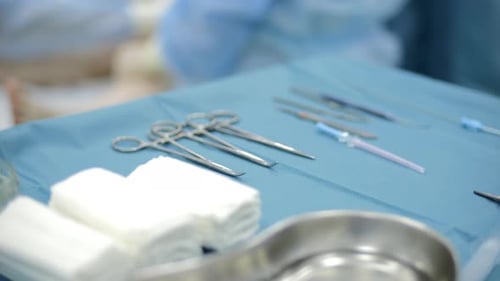 Sterile Surgical Instruments Laid Out on Blue Table