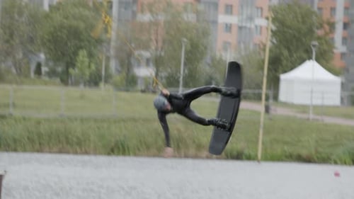 Man Wakeboarding and Flipping at Lake Resort