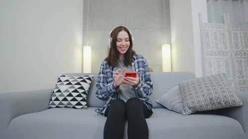 Woman Listening to Music on Couch at Home