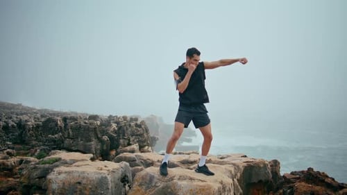 Professional Athlete Punch Air on Seaside Cliff Strong Boxer Training on Rocks