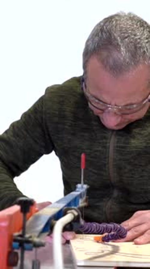 Concentrated carpenter cutting a piece of wood in workshop