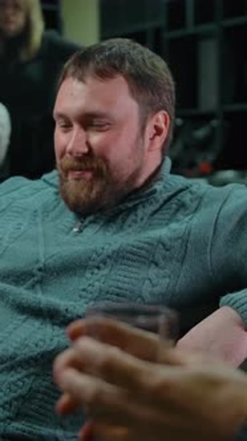 Man Smiles Accepting Glass of Liquor