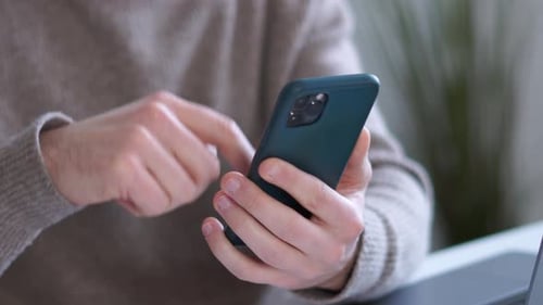 Adult Using Smartphone at Home or Workplace