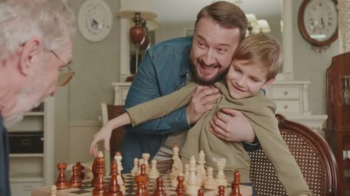 Family playing chess together indoors close up
