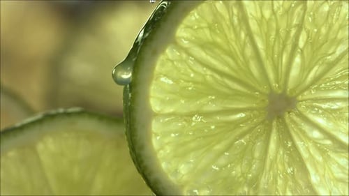 Drop of Lime Juice Flow Down the Surface of a Ripe Juicy Lime Slice