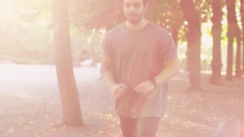 Young Handsome Man using Smart Watch during Morning Run in Park