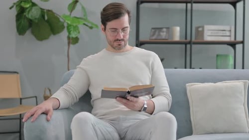 Man Reading a Book on Couch