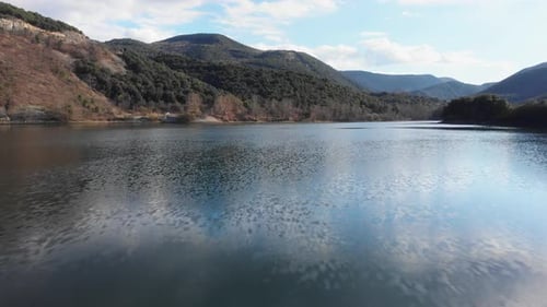 Low altitude drone flight over calm and quiet Mountain lake sunny summer day