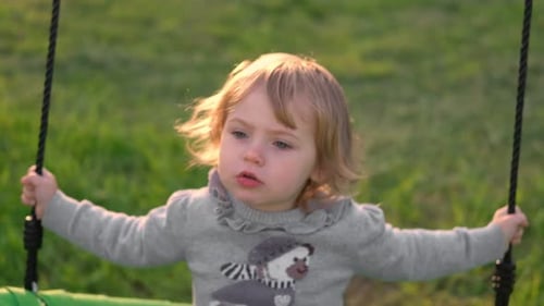 Girl on a Swing Little 2 Years Child Swinging in Summer at Sunset Slow Motion of Beautiful Baby