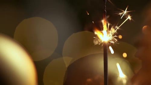 Burning Sparkler with Golden Bokeh in Dark Home