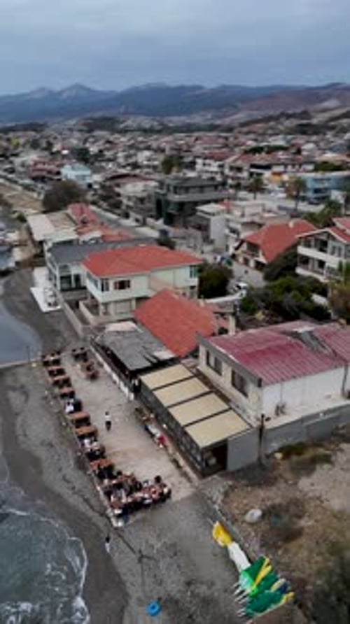 4K Drone Footage of a Seaside Venue with Outdoor Tables and Coastal View