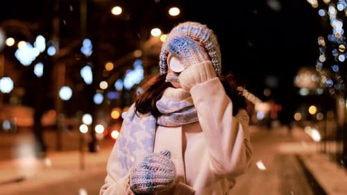 Woman Drinks Coffee on Snowy Night Street