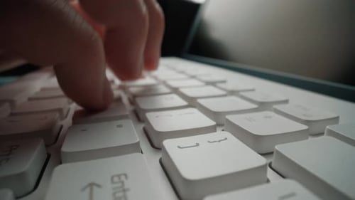 Close-up typing on keyboard with man fingers. Macro soft focus dolly shot. Glean
