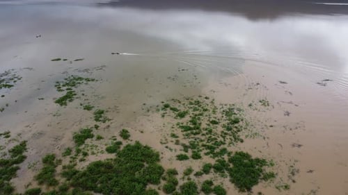 Aerial view of longtail boats in the river flowing after heavy rains and flooding in the rainy seaso