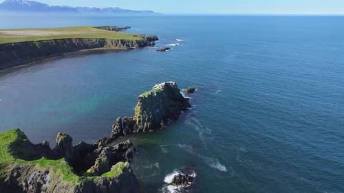 Aerial view of rugged cliffs and ocean waves, Iceland.