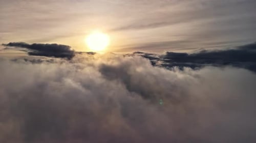 beautiful shot of the sun and the horizon passing through the moving clouds high in the sky