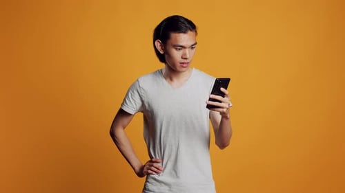 Excited Young Man with Smartphone Celebrating Good News