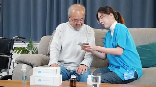 Woman nurse caregiver show prescription drug to senior man at nursing home