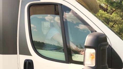 Woman Lowers Blind in Camper Window