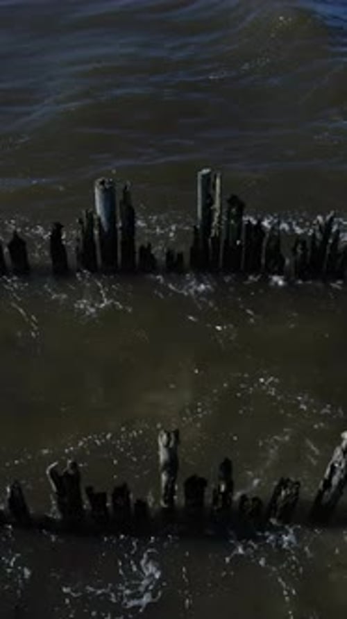 Ocean Waves Crashing on Weathered Coastal Posts