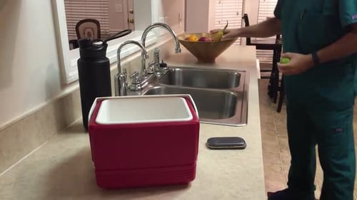 Male nurse packing lunch before heading out to work at hospital