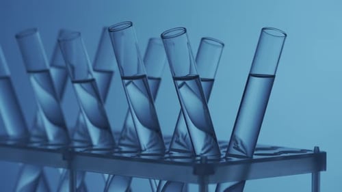 Close Up Video Neon Blue Light Test Tubes Filled with Fluid in a Laboratory Scientific Experiment