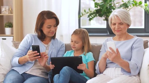 Three Generations Using Technology on Sofa
