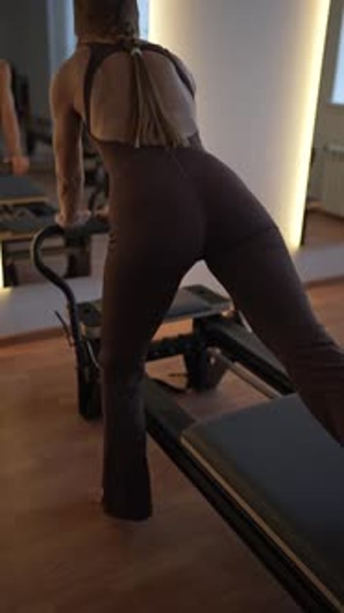 Woman Training Pilates on the Reformer Bed Reformer Pilates Studio Machine for Fitness Workouts in