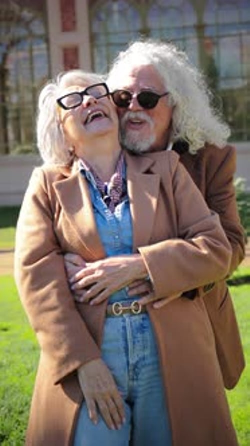Senior Couple Embrace and Laugh in Autumn Park