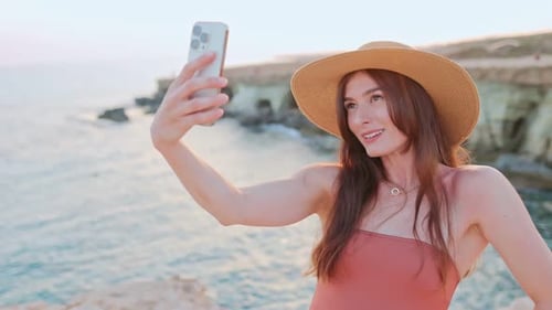 Young Woman Taking Selfie at Beach Sunset