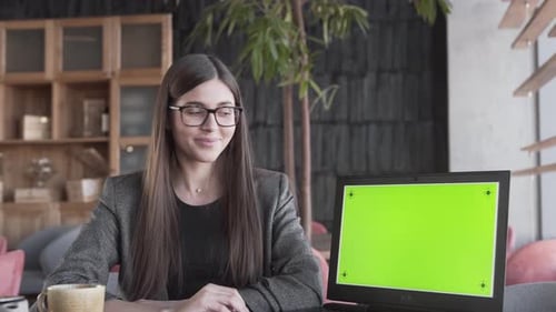 Young Happy Business Woman Pointing To A Laptop Computer With Green Screen
