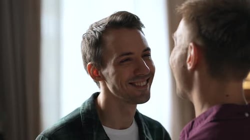 Two Men Smiling at Each Other Indoors