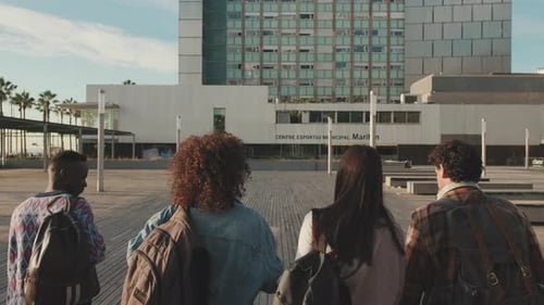 Classmates students walk down the street talking and laughing together