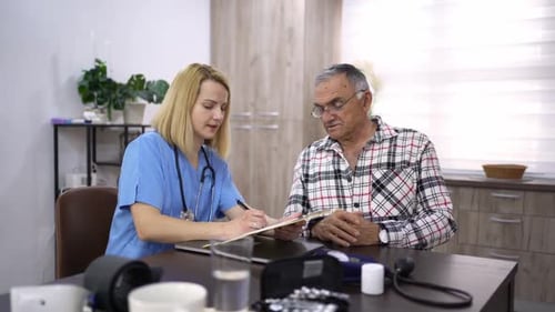 Woman Doctor Taking Notes During Appointment with Senior Man