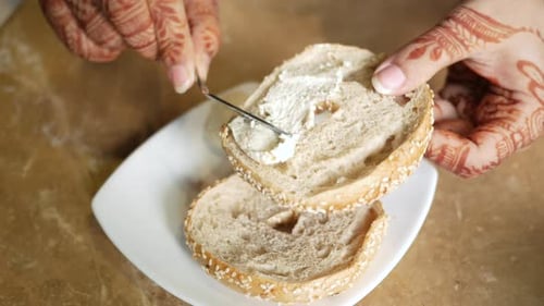 Crème au fromage tartinée sur pain de bagel frais