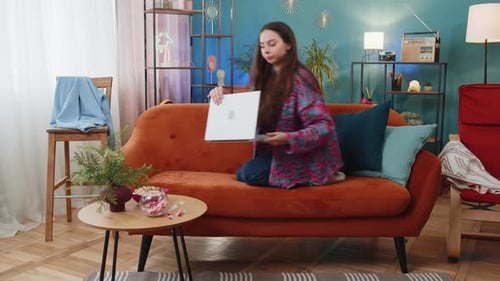 Young Woman Using Laptop Computer on Couch