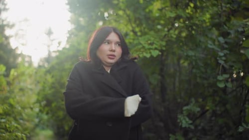 Serene Lady Adjusting Coat Breathing Deeply While Walking In Forest