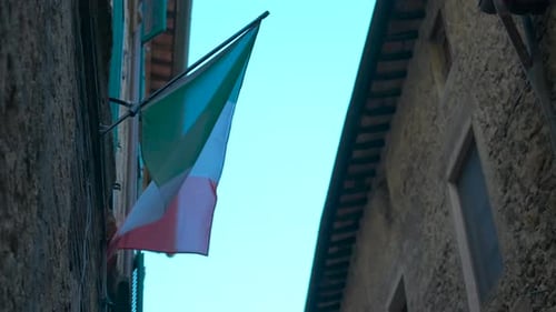 Italian Flag Waving Gently in Narrow Street