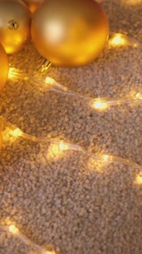 Golden Christmas Ornaments and Glowing Lights on Carpet