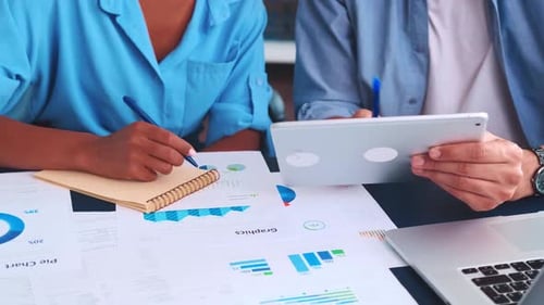Closeup Hands of Two Accountants Near Table with Documents and Calculator
