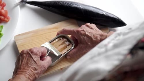 Opening Canned Fish to Prepare Meal at Home