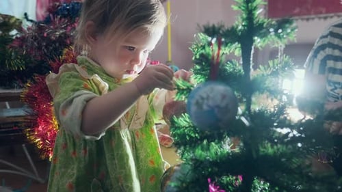 Child Decorating Christmas Tree at Home
