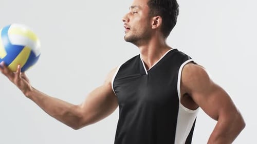 Young Man Balances Volleyball on Finger, Studio Shot