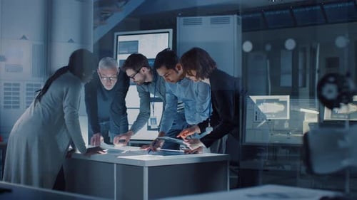 Team Collaborating on Technology at Table in Office