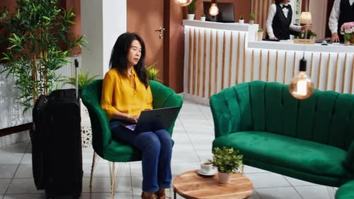 Hotel Guest Working on Laptop in Lounge Area Lobby